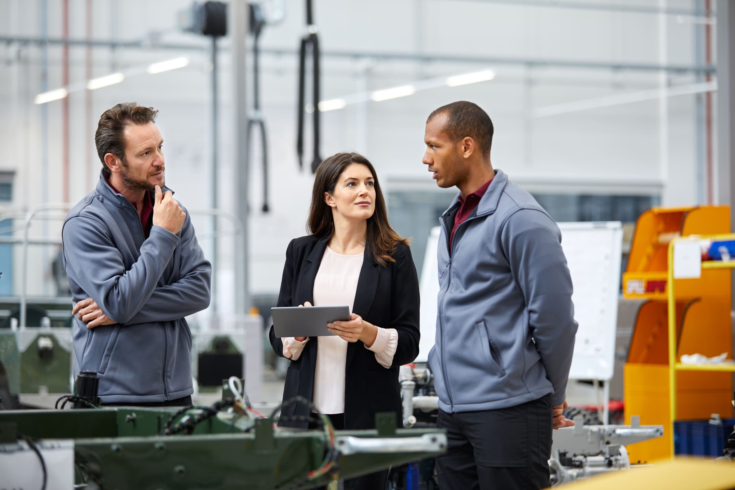 Professionals discussing in car factory
